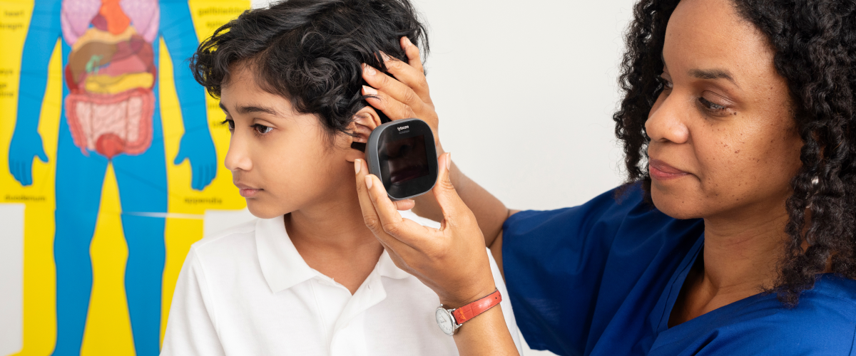Doctor taking temperature of child with ear thermometer