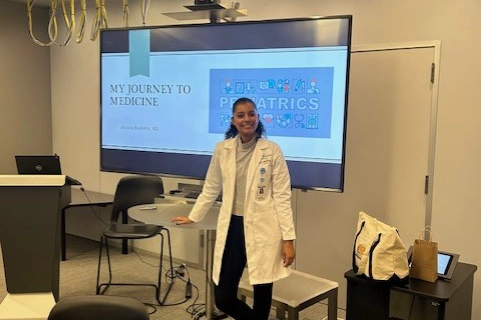 A provider inside a classroom standing in front of smart screen