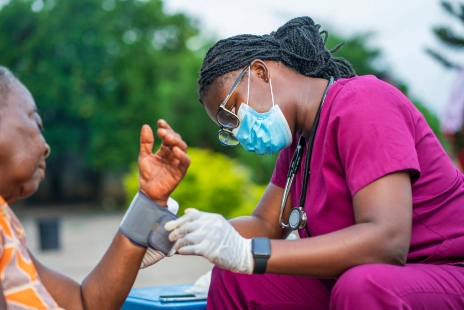 A doctor cares for a person in a community setting.