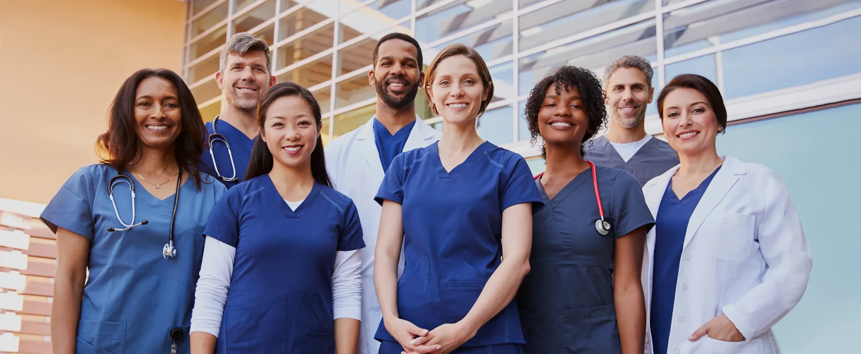 group of doctors and nurses stand shoulder to shoulder in two rows
