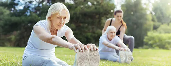 two adults exercising in a field